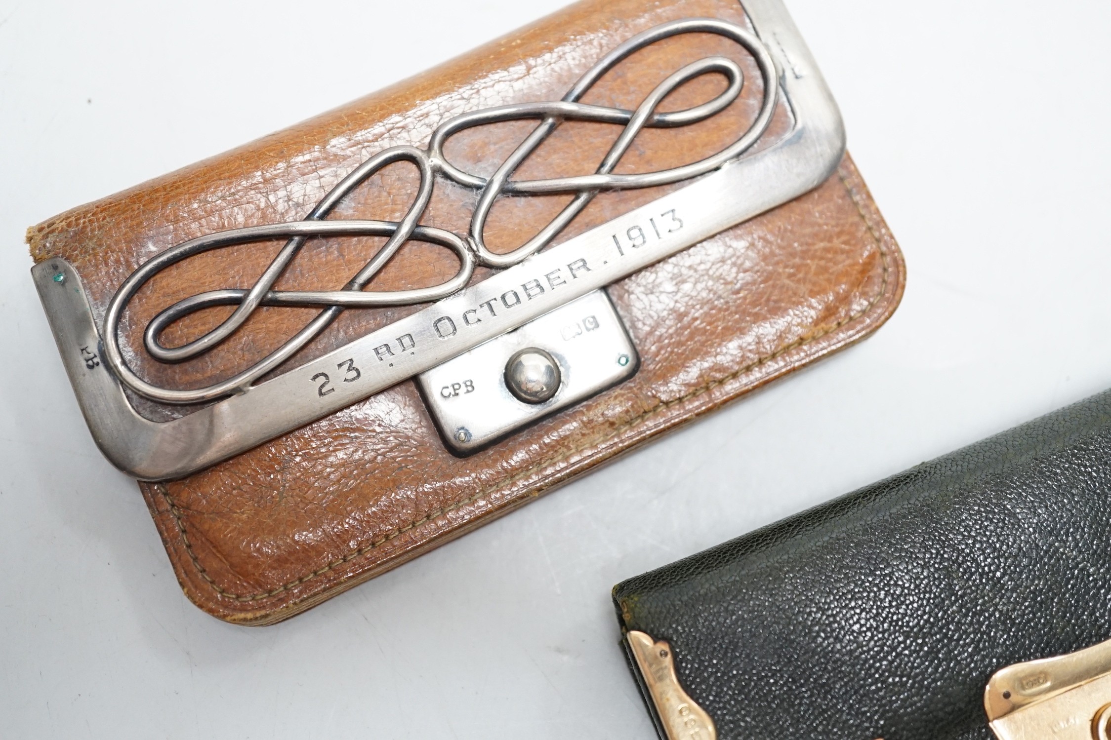 A late Victorian 15ct gold mounted leather purse, 10.3cm and a later silver mounted leather purse.